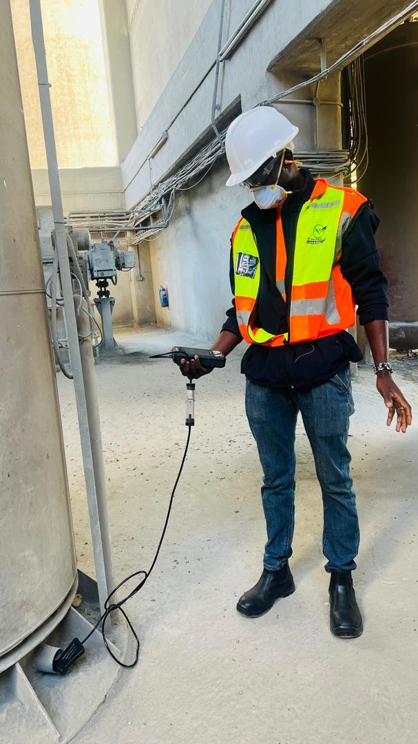 EnviroTrek Lab consultant taking measurements with a handheld sampling instrument at an industrial plant